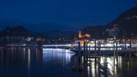 Night panorama of the lakefront of Laveno illuminated by many colored Christmas lightsのeditorial素材
