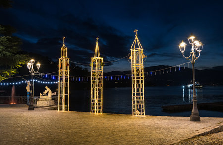 Laveno, Italy - 12-20-2022: Beautiful Christmas lights with the lake and a boat in the background in Laveno on Lake Maggioreのeditorial素材