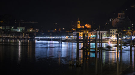 Night panorama of the lakefront of Laveno illuminated by many colored Christmas lightsのeditorial素材