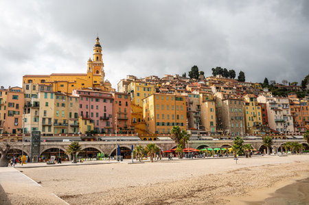 The beautiful beach of Menton with turquoise water and beautiful colorful houses in the backgroundのeditorial素材