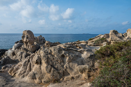 Wind-eroded rocks illuminated by the sun in the beautiful Punta Molentis beach in Villasimiusの写真素材