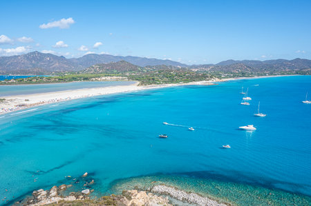 VIllasimius, Italy - 09-05-2024: Aerial view of the beautiful beach of Porto Giunco in Villasimius with white sand and crystal clear water with the Notteri pond in the backgroundの写真素材