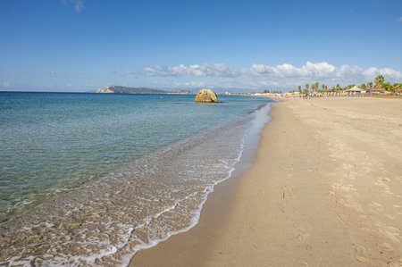 Poetto beach in Cagliari, with blue water and a characteristic rock in the seaの写真素材