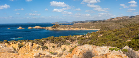 Landscape of the south-west coast of Sardinia with cliffs, blue sea, and white cloudsの写真素材