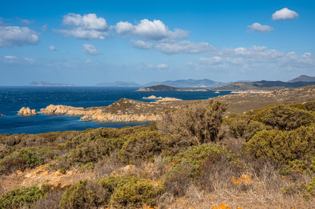Landscape of the south-west coast of Sardinia with cliffs, blue sea, fjords and white cloudsの写真素材