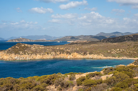 Landscape of the south-west coast of Sardinia with cliffs, blue sea, fjords and white cloudsの写真素材
