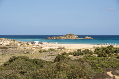 The beautiful beach of Su Giudeu in the south of Sardinia with transparent and turquoise water and a small island in front of the bayの写真素材