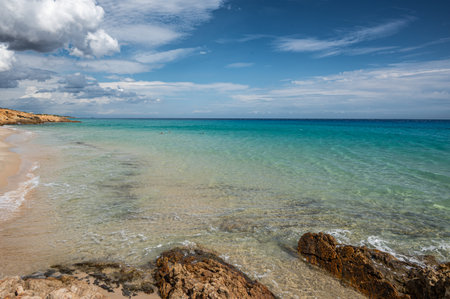 The beautiful beach of Sardinia with fine sand and blue and turquoise water and storm clouds on the horizonの写真素材