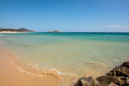 The beautiful beach of Su Giudeu in the south of Sardinia with transparent and turquoise water and a small island in front of the bayの写真素材
