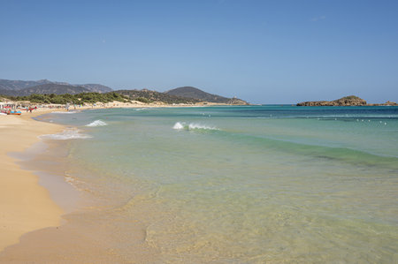 The beautiful beach of Su Giudeu in the south of Sardinia with transparent and turquoise water and a small island in front of the bayの写真素材