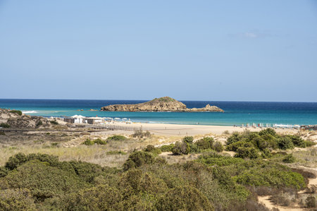 The beautiful beach of Su Giudeu in the south of Sardinia with transparent and turquoise water and a small island in front of the bayの写真素材