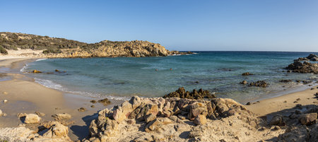 The beautiful beach of Su Giudeu in the south of Sardinia with transparent and turquoise water and a small island in front of the bayの写真素材