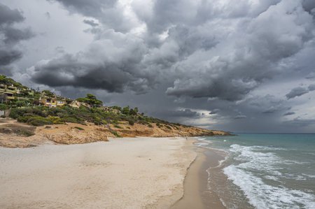 The beautiful beach of Pinus in Sardinia with fine sand and blue and turquoise water and storm clouds on the horizonの写真素材