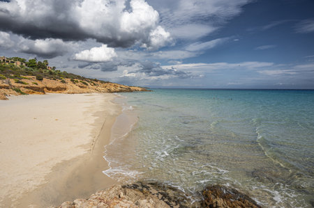 The beautiful beach of Pinus in Sardinia with fine sand and blue and turquoise water and storm clouds on the horizonの写真素材
