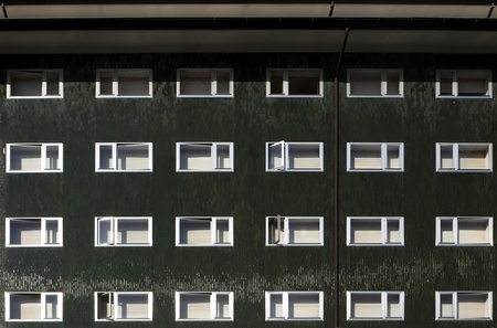 Dark green facade of apartment building with white shuttersの写真素材
