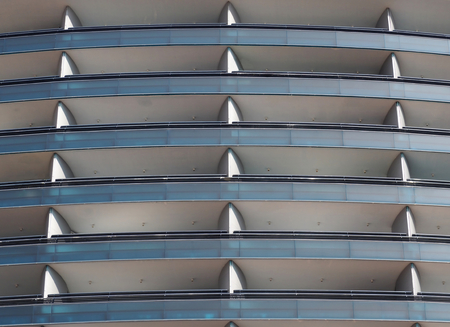 Blue glass and metal facade of a residential building with long terracesの写真素材