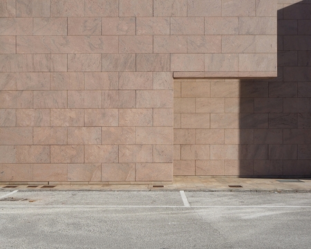 Urban background. Concrete road made of blocks. Part of the wall recess is in shadowの写真素材