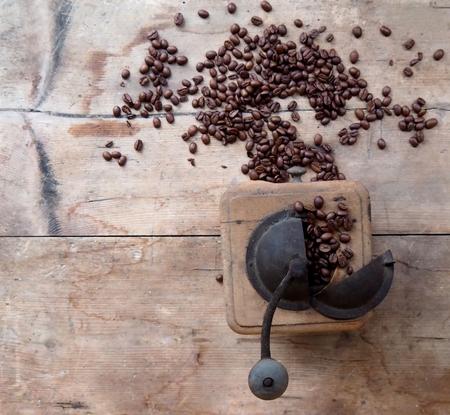 Rustic and ancient coffee grinder on weathered wood tableの写真素材