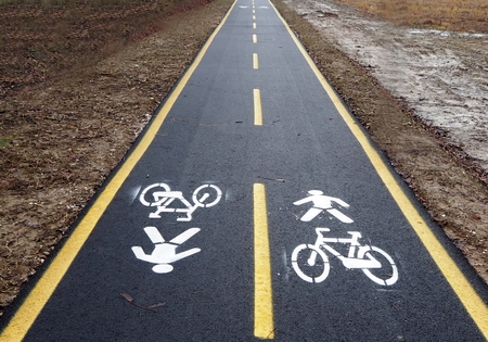 Straight asphalt bike lane between the muddy winter countrysideの写真素材