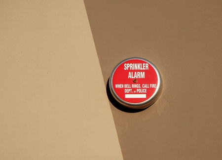 Sprinkler fire alarm on bicolored wall background. When the bells ring, call fire department or police.の写真素材