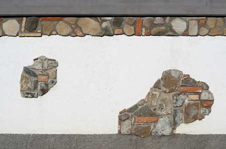 White wall with natural stone and brick cladding. Gray cement at the upper and lower endsの写真素材