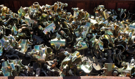 Brand new scaffolding pipe clamps in a heap. They are used mainly in construction for pipe connectionの写真素材