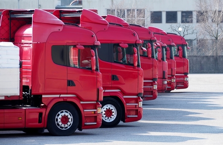 Red trucks lined up in a parking lot, ready to go.の写真素材