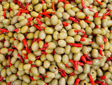 Green olives and red hot chili peppers, specialty of southern Italy. Food backgroundの写真素材
