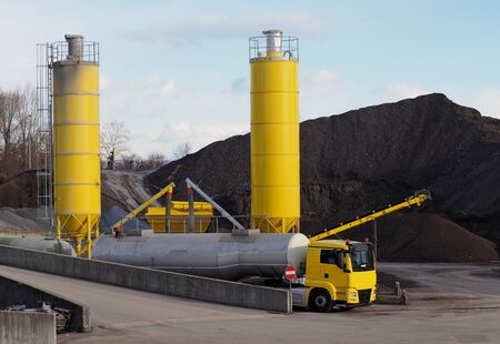 A bitumen truck fills the tanks of the trailers from the industrial site silo