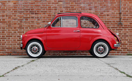 Udine, Italy. April 12 2019. An iconic vintage red Fiat 500 recently restored on brick wall backgroundのeditorial素材