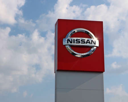 Reana, Italy. June 13 2019. Nissan logo in the car dealership of the area, against a blue sky with clouds. It is the symbol of the japanese car manufacturerのeditorial素材