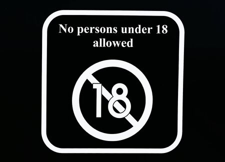No persons under 18 allowed, prohibition sign. White on black backgroundの写真素材