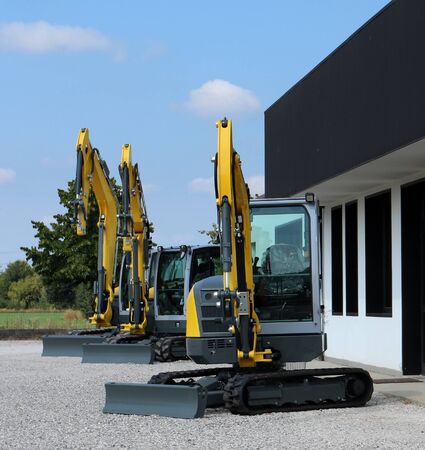 Brand new mini excavators in a rowの写真素材