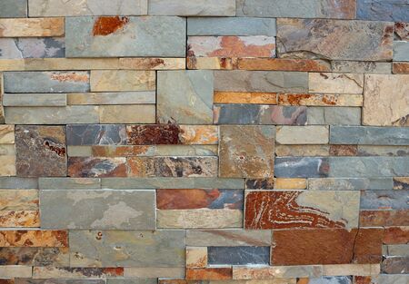 Wall cladding made of different sizes natural stone bricks. Colors are shades of red and gray. Background and texture.の写真素材
