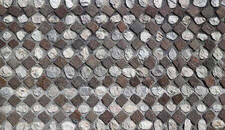 Exterior wall with decorative motif of circular white and black stones geometrically arranged. Background and textureの写真素材
