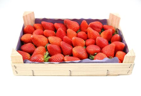 Wooden crate full of freshly harvested strawberries on white background. Side view.の写真素材