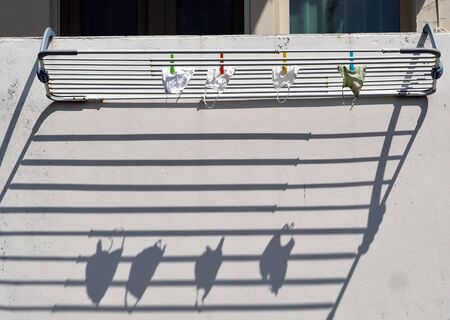 Protective face masks against coronavirus, hanging out to dry from the balconyの写真素材
