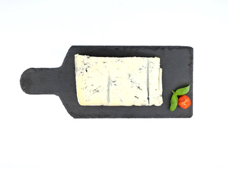 Gorgonzola, italian veined blue cheese, on a slate serving plate with cutting board shape. White background.の写真素材