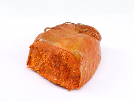 Nduja, inside its sausage casing, on white background. It is a traditional spicy, spreadable pork sausage from the region of Calabria in Southern Italy.の写真素材