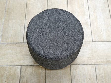 Top view of round fabric gray pouf. Wooden floor on the backgroundの写真素材