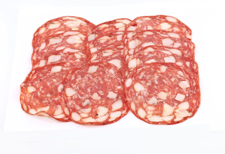 Slices of Tuscan Salami on white background. It is a traditional Italian salami hailing from Tuscany, made with pork ham, belly, lard, and spices.の写真素材