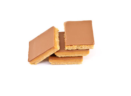 Caramel shortcakes, or shortbread, on white background. They are biscuits made of shortbread topped with caramel and chocolate.の写真素材
