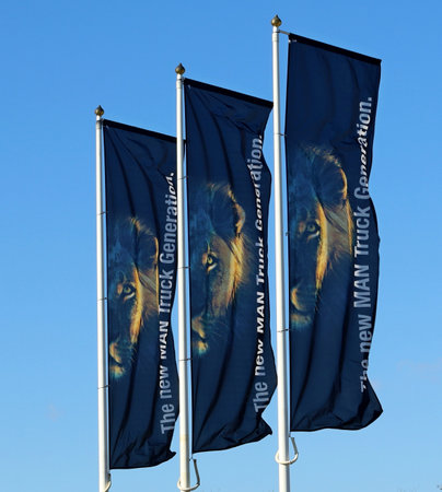 Udine, Italy. February 14, 2021. Man Truck banner flags waving against the sky outside the delaership of the area. It is a German manufacturing company of commercial vehicles and dのeditorial素材