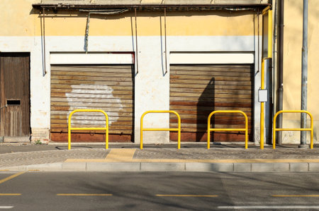Abandoned store at the roadside. Sidewalk, bus stop and yellow pedestrian barrier in front. Grunge background for copy spaceの写真素材