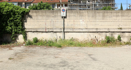 No stopping sign on a grunge concrete wall in a desolate urban road, Background for copy space.の写真素材
