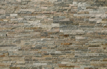 Stone cladding wall made of striped stacked bricks of multicolor rocks. Panels for exterior, background and texture.の写真素材