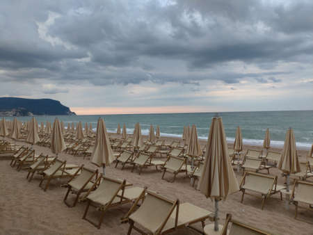 Beach in Italy with closed umbrellas in the evening after the stormの写真素材