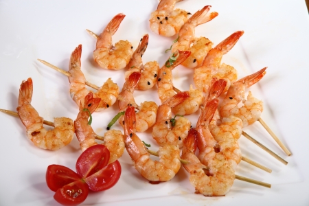 shrimp skewers on white plateの写真素材