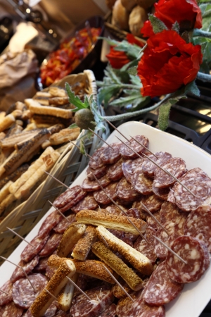 plate with slices of salami and bread sticksの写真素材