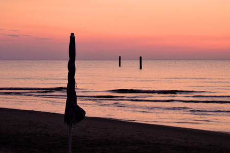 seascape seen from the beach while the sun rises on the horizonの写真素材